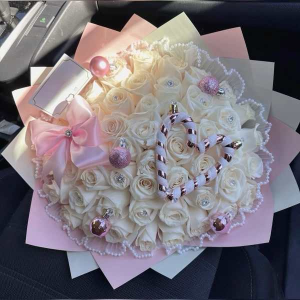 Bouquet of white roses with pink ribbon and pearl accents
