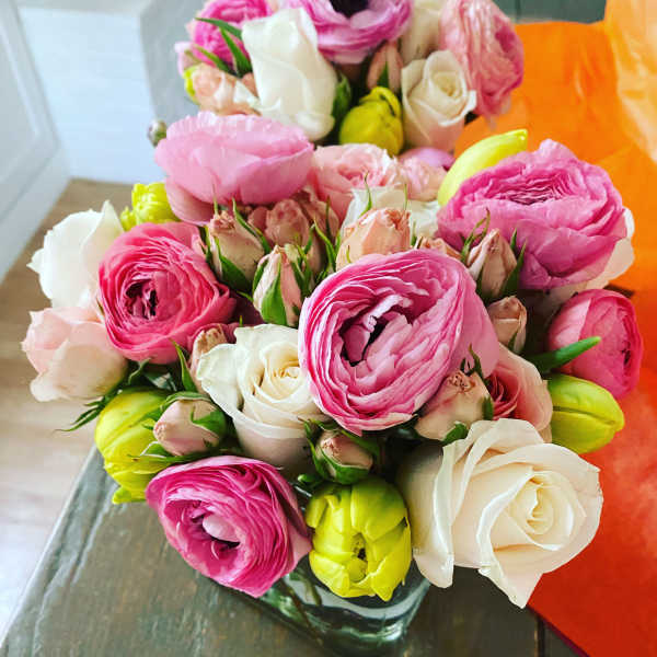Bouquet of pink, white, and yellow flowers in a glass vase