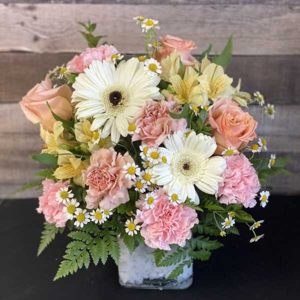 Mixed bouquet in a square glass vase with pink and white flowers