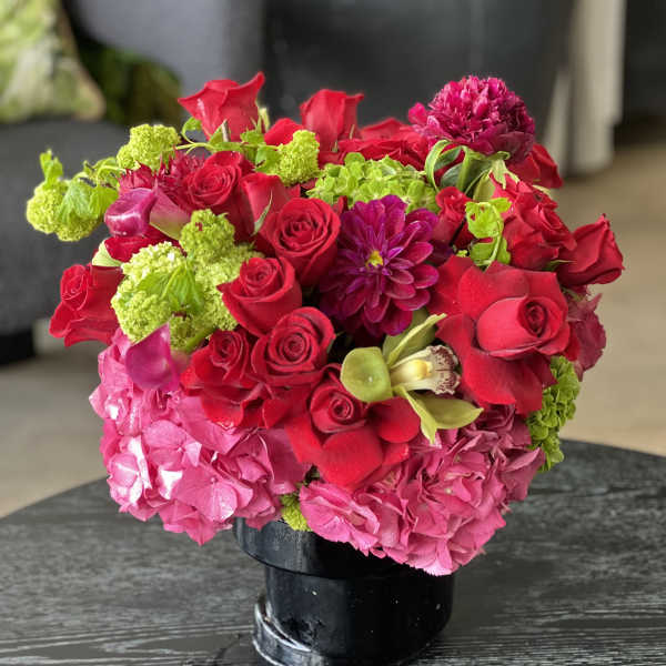 Bouquet of red and pink flowers in a black vase