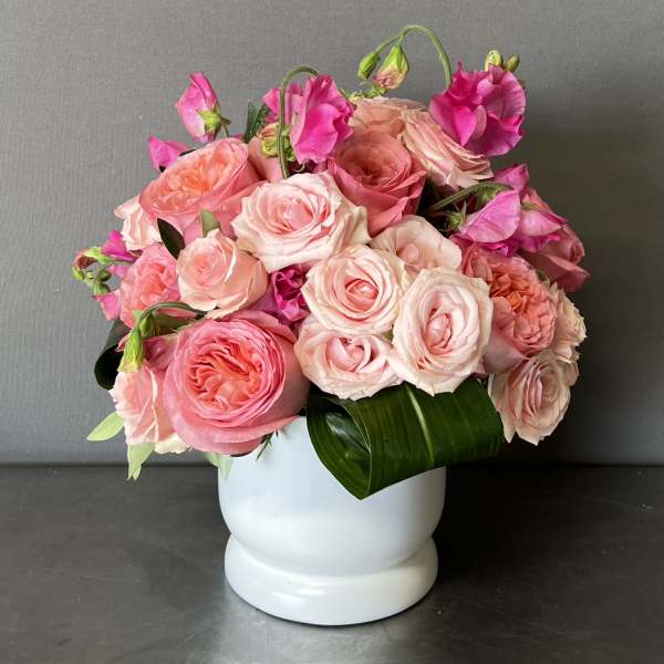Pink and peach rose bouquet in a white vase