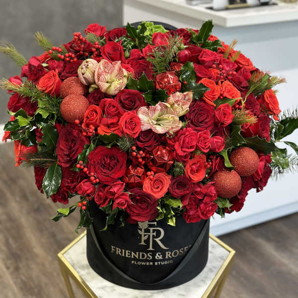 Large red rose arrangement in a black hatbox with glitter ornaments
