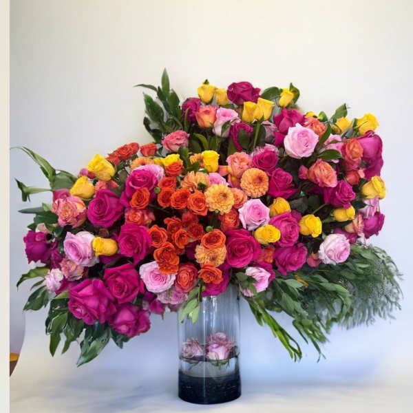 Large mixed rose arrangement in a clear glass vase
