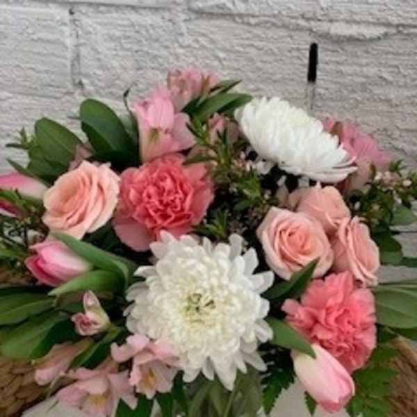 Pink and white mixed flower arrangement in a glass vase