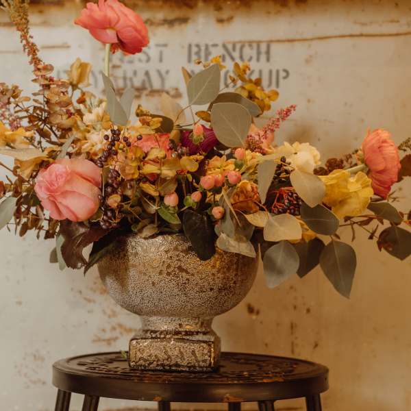 Mixed floral arrangement in a textured gold vase