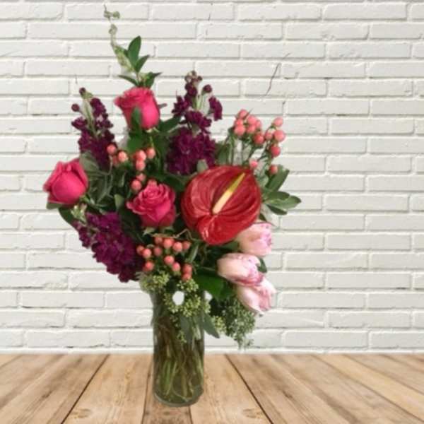 Mixed bouquet in a glass vase with pink roses and red anthurium