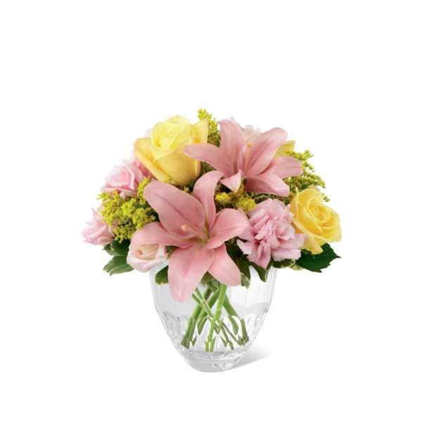 Pink lilies and yellow roses in a clear glass vase