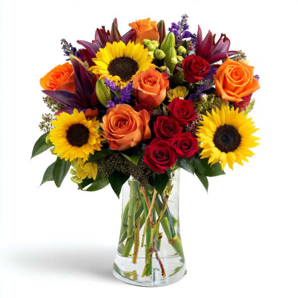 Bouquet of sunflowers, roses, and lilies in a clear glass vase