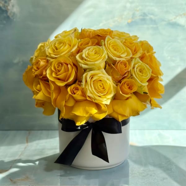 Yellow rose bouquet in a white hatbox with a black ribbon