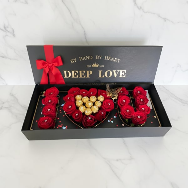 Red roses and chocolates arranged in a black gift box
