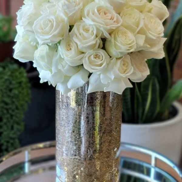 White rose bouquet in a tall metallic vase