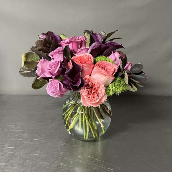 Pink and purple rose bouquet in a clear glass vase