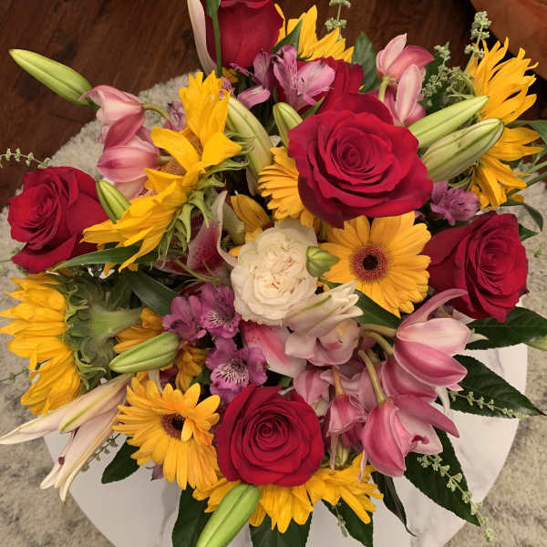 Mixed bouquet of red roses, yellow sunflowers, and pink lilies