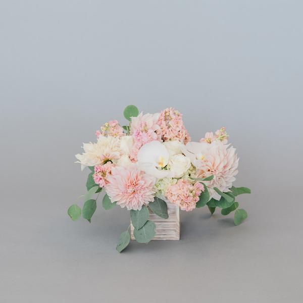 Blush and white floral arrangement in a wooden cube vase