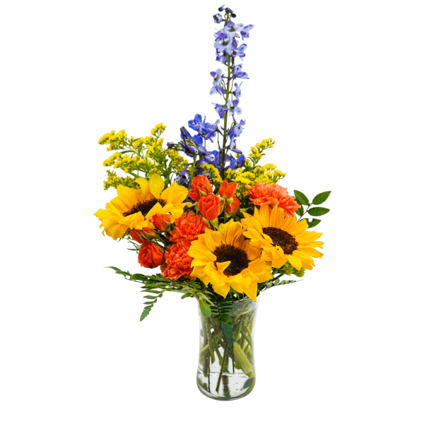 Bouquet of sunflowers, orange carnations, and blue delphinium in a clear glass vase