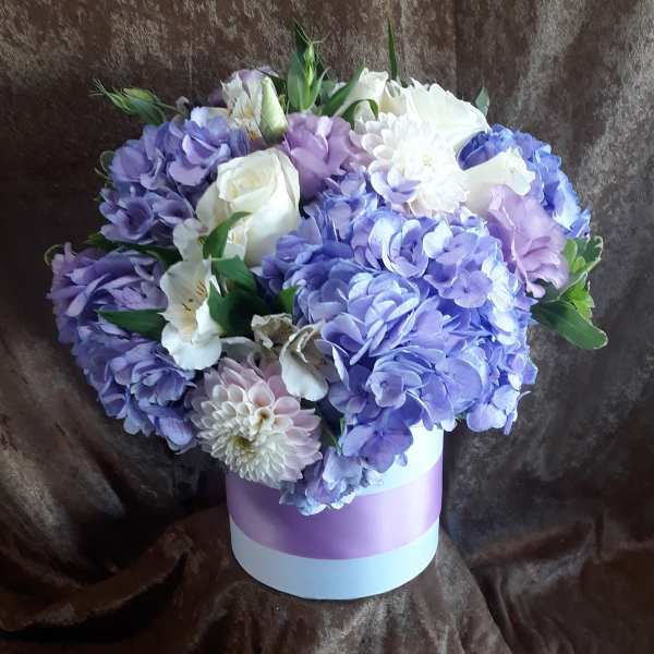 Lavender and white bouquet in a round pastel box