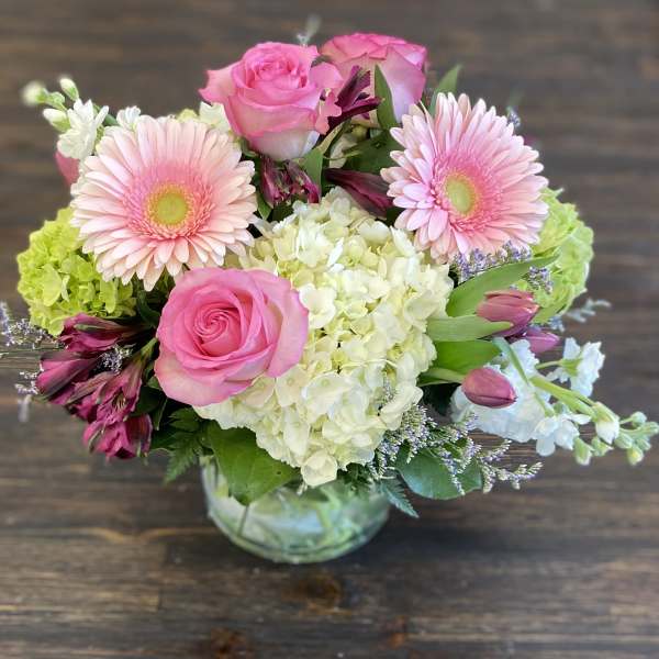 Pink roses and gerbera daisies in a glass vase