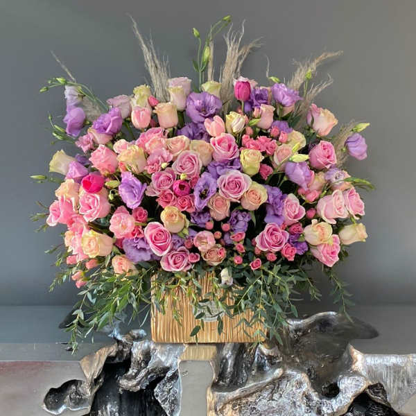 Large bouquet of pink and purple roses in a gold container