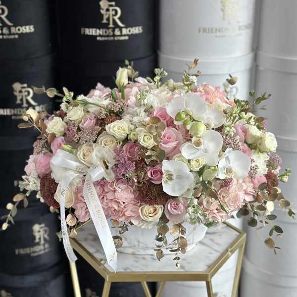 Large pastel bouquet of roses, orchids, and hydrangeas in a white hatbox