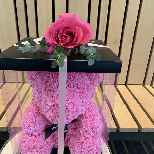 Pink rose teddy bear in a clear gift box with a ribbon