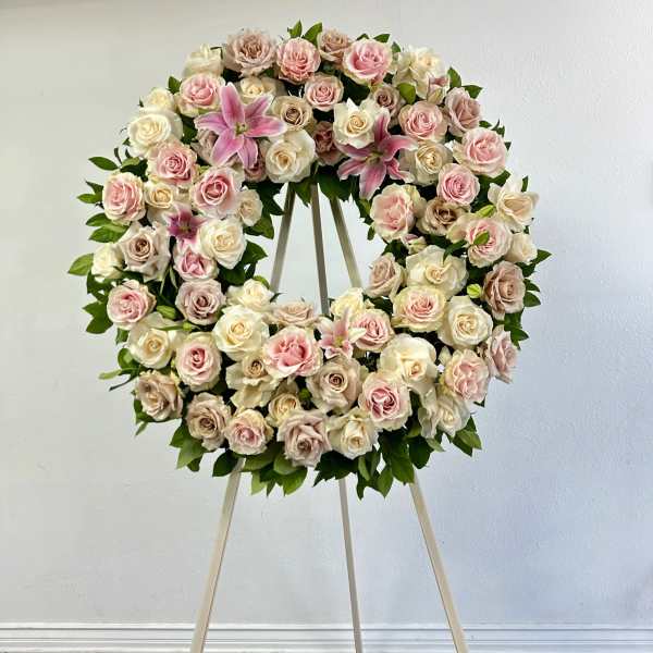 Heart-shaped wreath of pink and cream roses on an easel