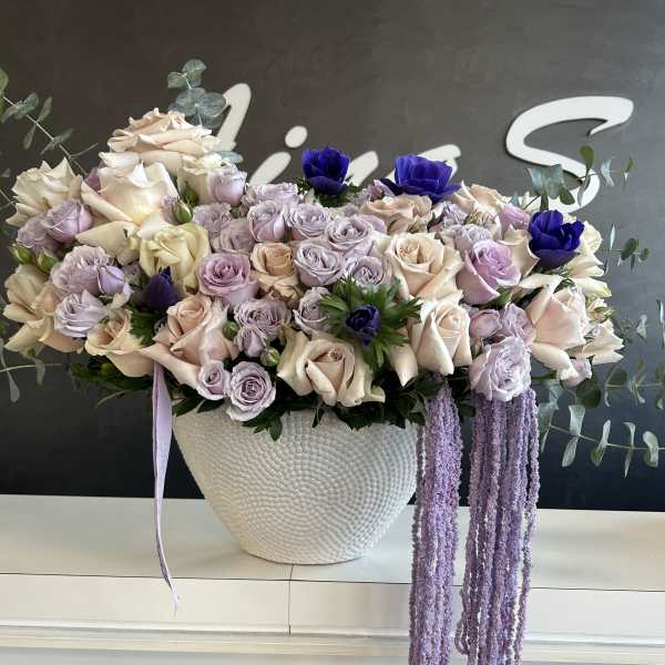 Lavender and cream rose arrangement in a white textured vase