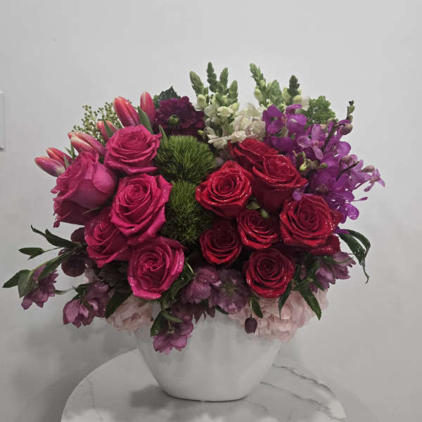 Pink and red rose arrangement in a white vase