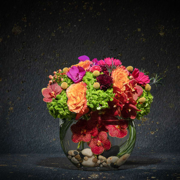 Colorful mixed flower arrangement in a glass bowl vase