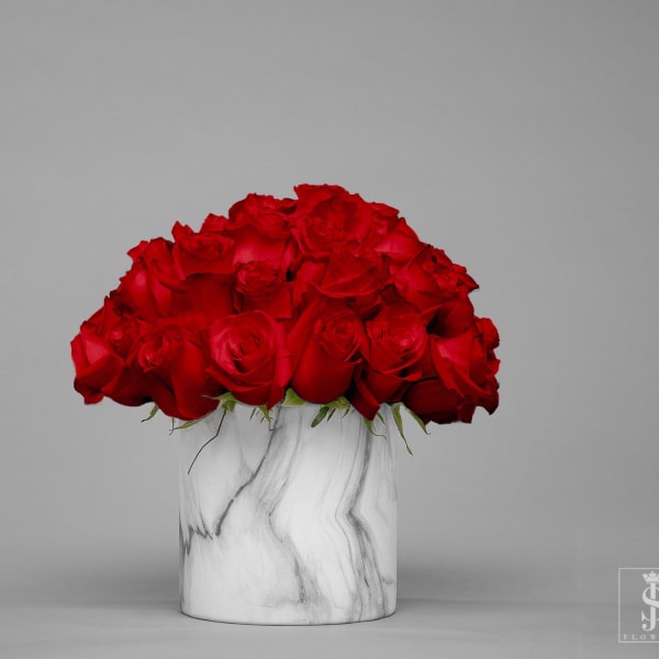 Red roses arranged in a white marble vase