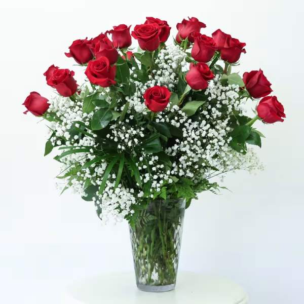 Red roses and baby's breath in a clear glass vase