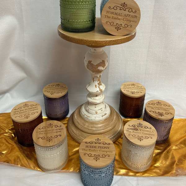Assorted scented candles in textured glass jars on a pedestal stand