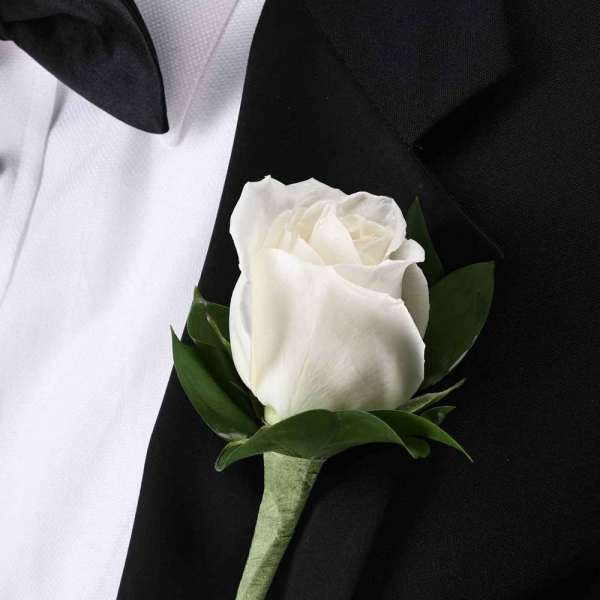White rose boutonniere on a black suit jacket