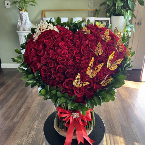 Heart-shaped bouquet of red roses with butterflies and a red ribbon