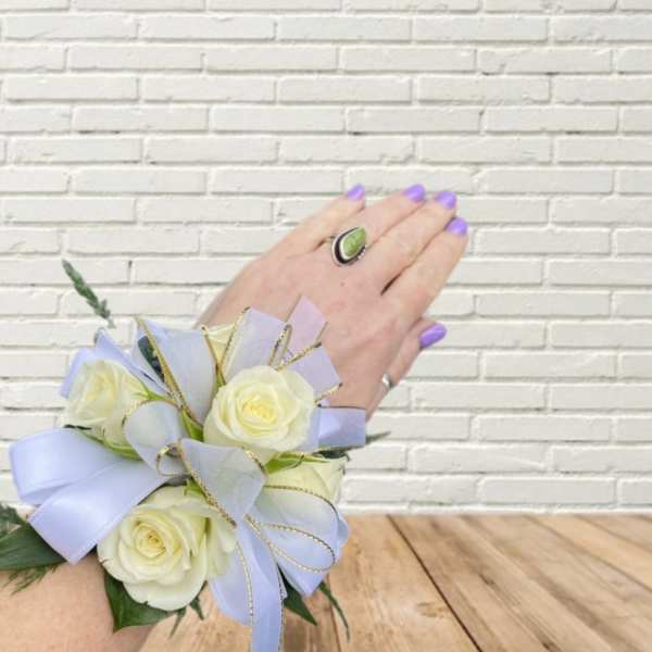White rose wrist corsage with lavender ribbon and gold trim