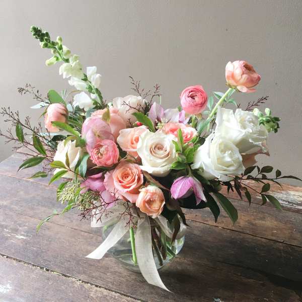 Pastel bouquet of roses and ranunculus in a glass vase