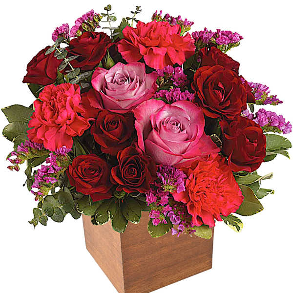 Bouquet of red and pink roses in a wooden cube vase