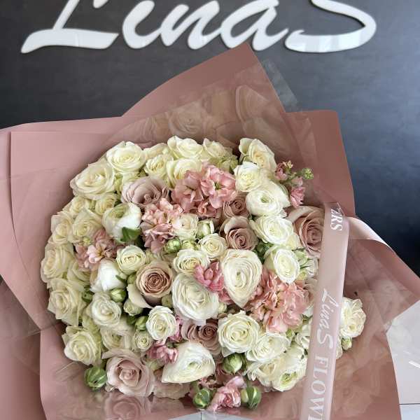 Large bouquet of cream and blush roses wrapped in pink paper