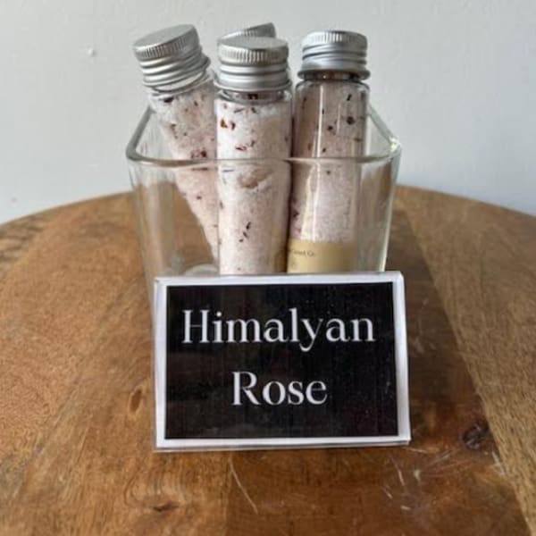 Three small vials of Himalayan rose bath salts in a glass holder