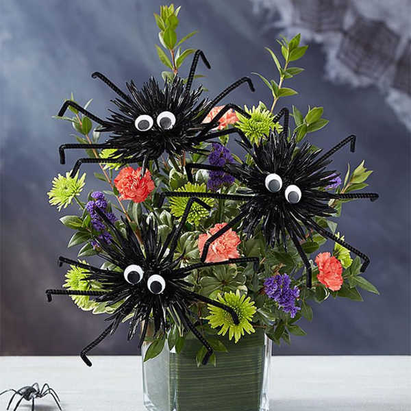 Halloween bouquet with spider decorations in a glass vase