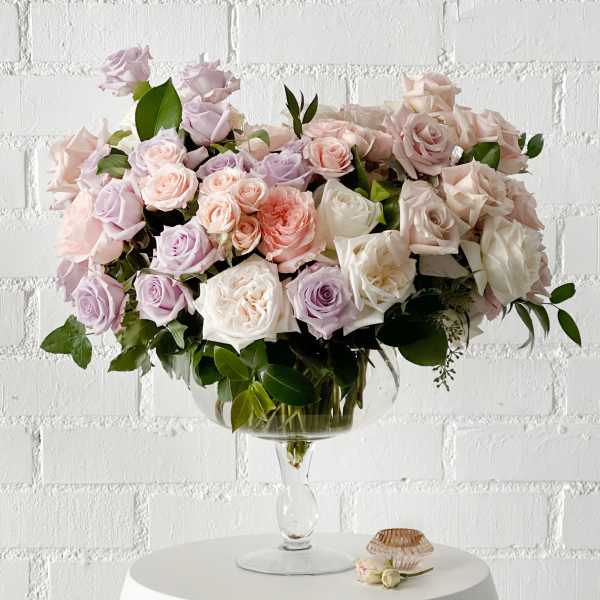 Large pastel rose arrangement in a clear glass vase