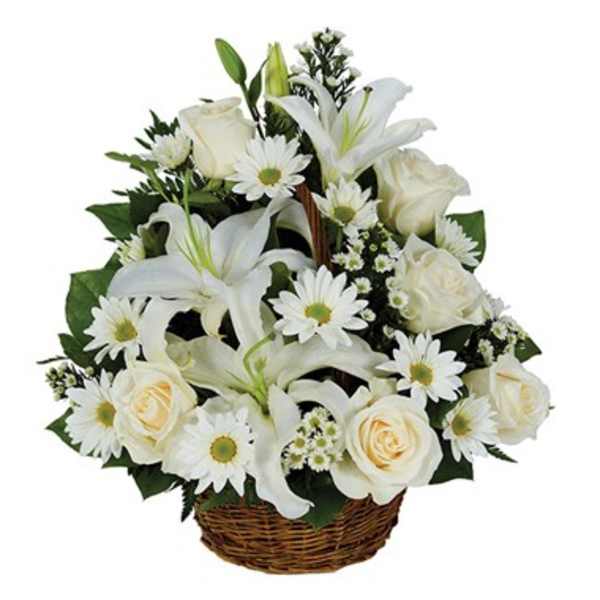 White lilies, roses, and daisies arranged in a wicker basket