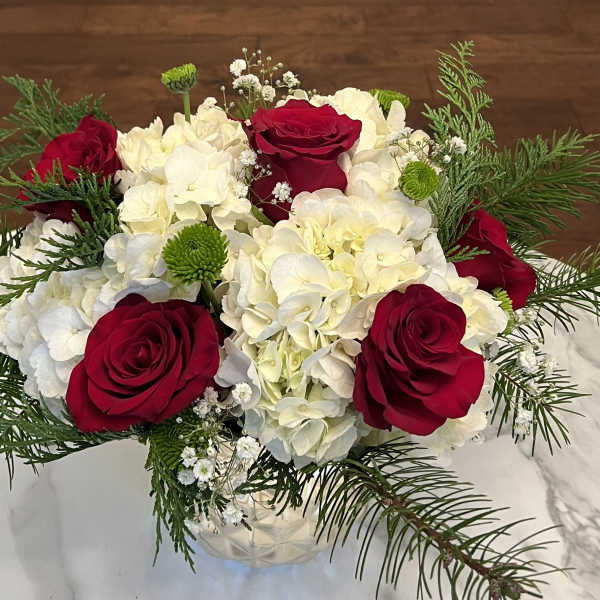 Red roses and white hydrangeas in a clear glass vase