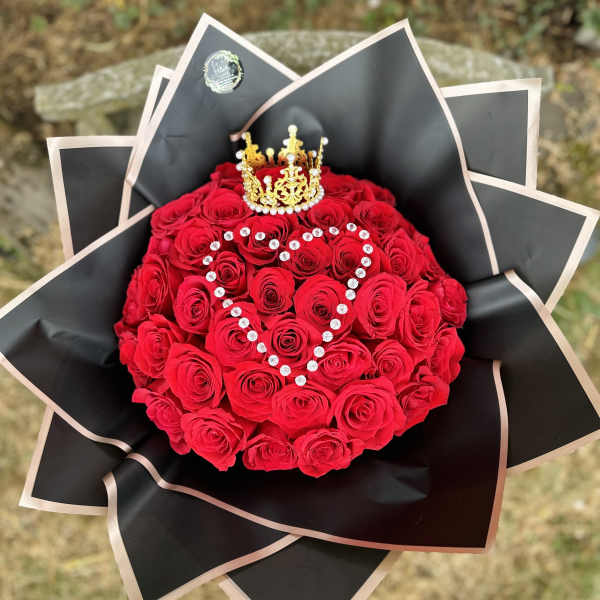 Red rose bouquet with a jeweled heart design and gold crown topper