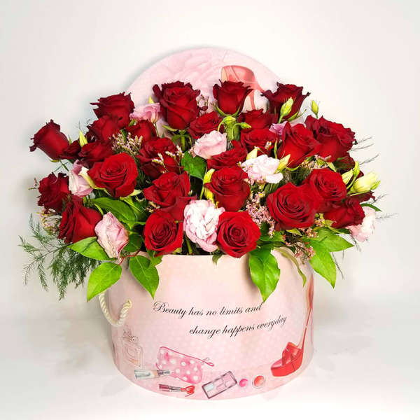 Red and pink roses arranged in a pink round gift box