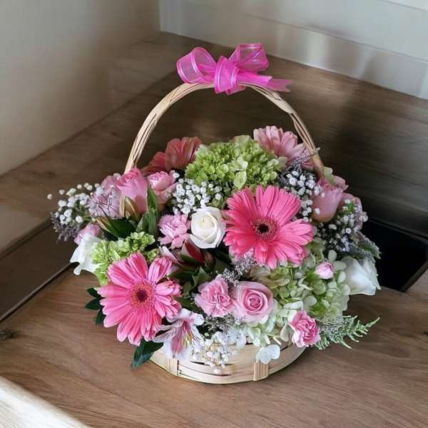 Pink and white flower basket with a ribbon handle