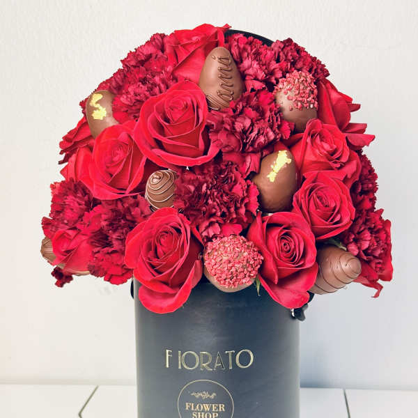 Red roses and chocolates arranged in a black hat box