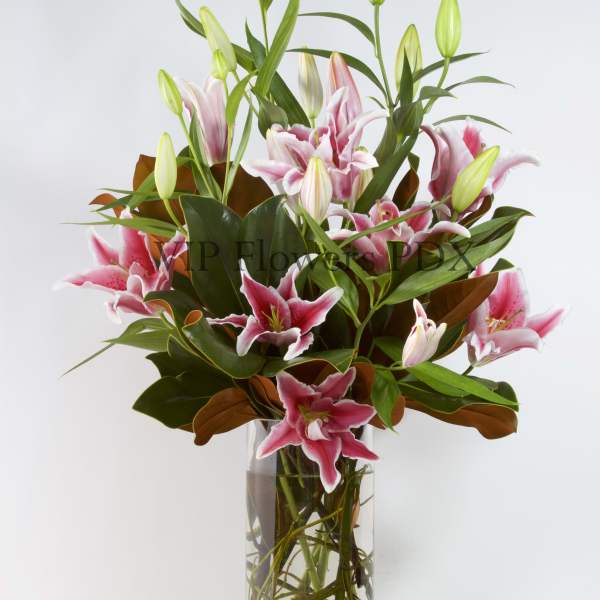 Pink lilies arranged in a clear glass vase