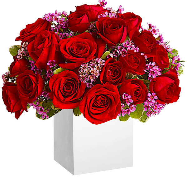 Red roses with pink filler flowers in a white box vase