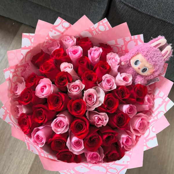 Bouquet of red and pink roses with a pink plush toy