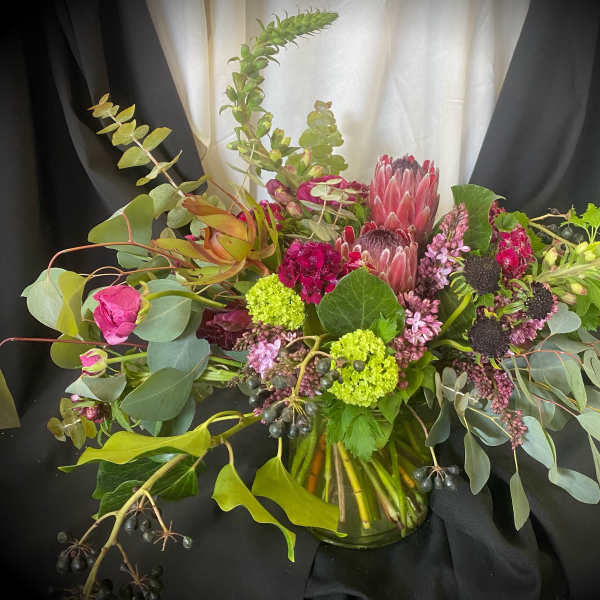 Mixed bouquet with pink protea and eucalyptus in a glass vase